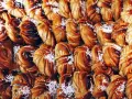 En stor hög med gyllene kanelbullar, perfekta för kanelbullens dag. Strösslade med pärlsocker.