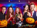 Glada vuxna firar halloween med drinkar och pumpor. En vampyr, en häxa och en djävul njuter av festen. Perfekt för halloween lekar vuxna!