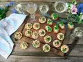 Små, läckra tilltugg till bubbel, serverade på en rustik bricka med blommor och glas. Perfekt för festliga tillfällen.
