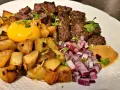 En klassisk biff Rydberg med tärnad biff, stekt potatis, rå äggula, hackad rödlök och en klick senap.