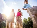 Barn hoppar säcklöpning i solsken, en klassisk midsommaraktivitet. En del av en femkamp midsommar.