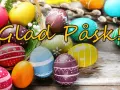 Färgglada påskägg i en korg och utspridda, med texten "Glad Påsk!".