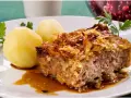 En bit kålpudding med kokt potatis och en skvätt sås. Perfekt för ett klassiskt kålpudding recept.