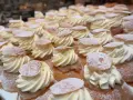 En hel hylla full med semlor, redo för semmeldagen. Krämig grädde och pudrat florsocker.
