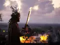 En person med hjorthorn och lövverk håller en fackla vid en eld. En mystisk stämning under halloween i Irland.