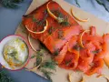 Rökt lax med apelsinzest och dill, serverad med en krämig sås till lax. Perfekt för en festlig måltid.