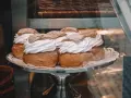 Sju semlor på ett fat, redo för pannkakans dag. Krämig grädde och pudrat socker.