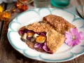 Matiga pannkakor fyllda med svamp, halloumi och rödkål, dekorerade med en rosa blomma.