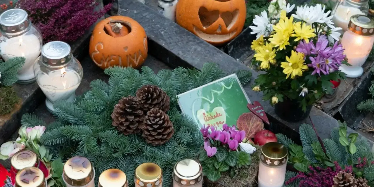 Gravdekoration med pumpor, ljus och blommor. En påminnelse om varifrån halloween kommer, med en känsla av minne och höst.