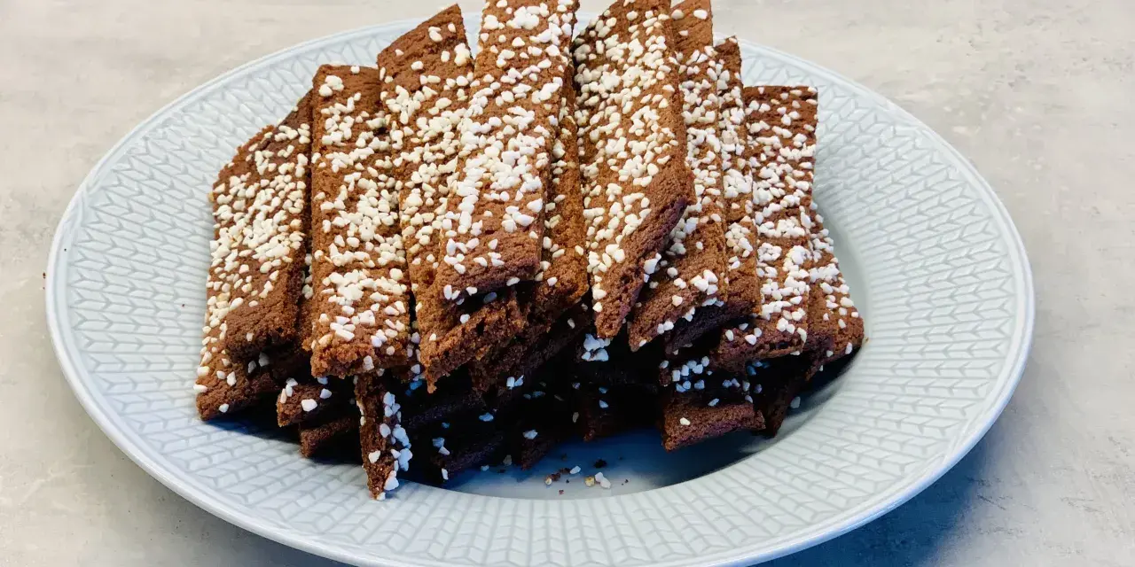 En tallrik med chokladsnittar, toppade med pärlsocker. Perfekt för ett enkelt chokladsnittar recept.