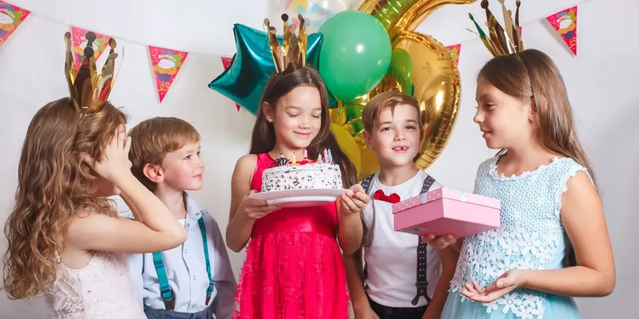 Barn med kronor firar födelsedag med tårta och presenter. Perfekt för barnkalas lekar 6 år.