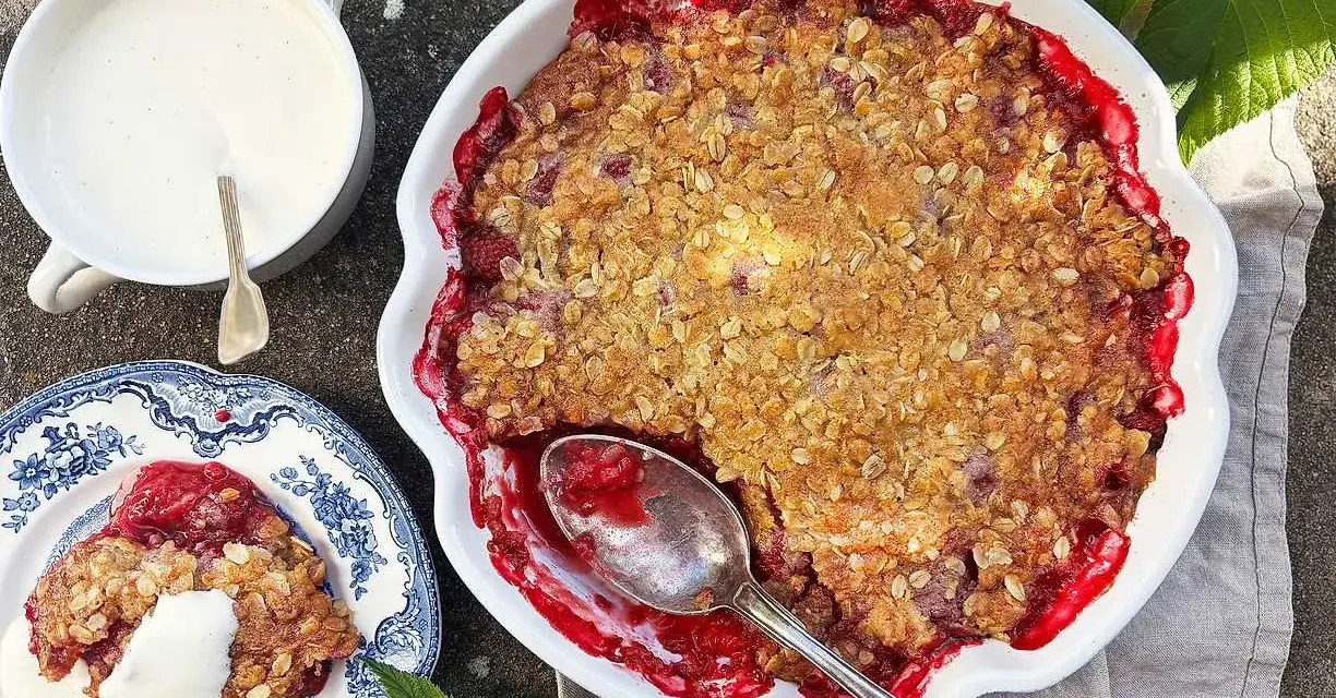 En härlig hallonpaj med krispigt täcke, serverad med vaniljsås. Ett perfekt hallonpaj recept för sommaren.