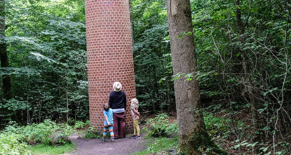 Familj utforskar en tegelkolonn i skogen, en av många Kristianstad aktiviteter.