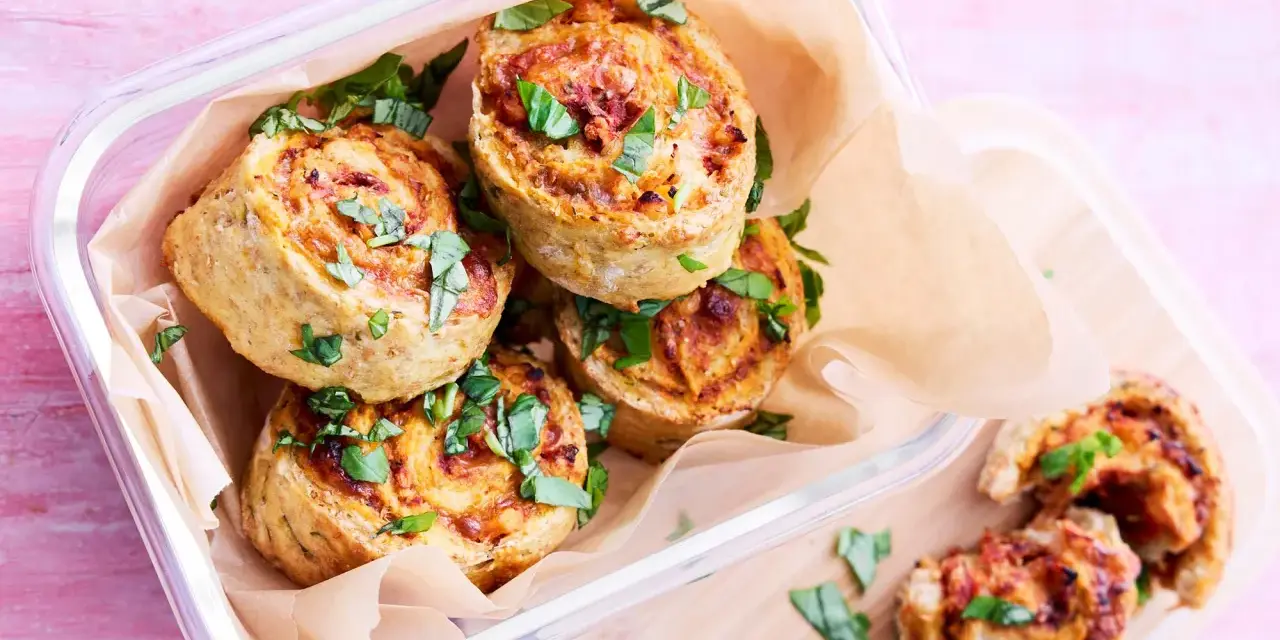 Läckra pizza bullar i en glasburk, toppade med färsk basilika. Perfekta för en picknick eller som mellanmål.