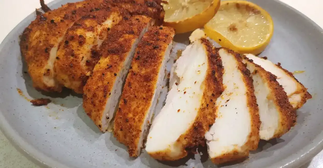 Saftig kyckling i airfryer, skivad och serverad med grillade citronklyftor. Perfekt för en snabb och god middag.