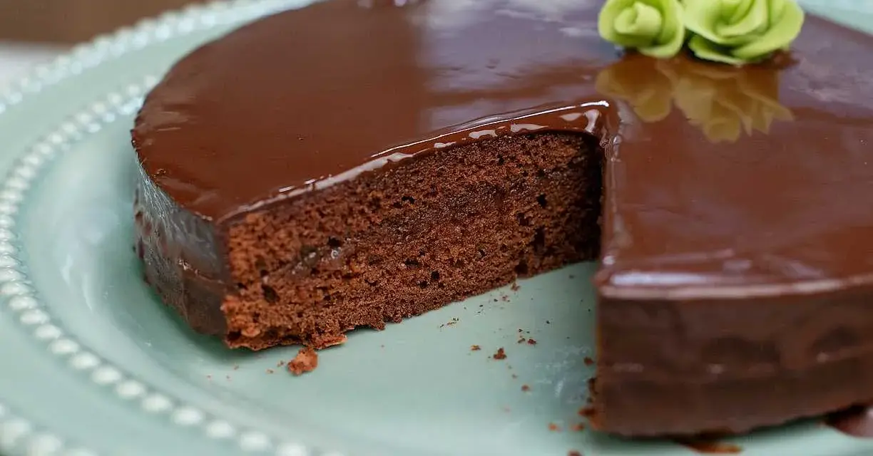 En saftig chokladkaka med blank glasyr, perfekt för ett sachertårta recept. Garnerad med gröna marsipanrosor.