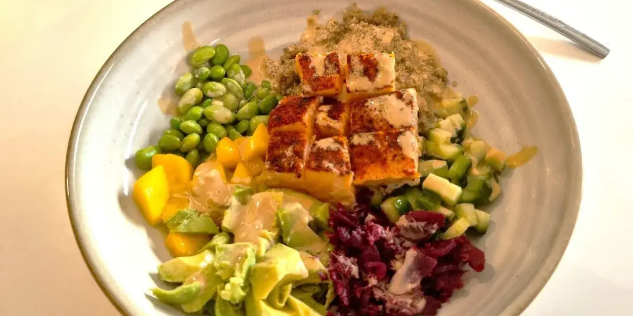 En färgstark bowl med lax, quinoa, edamamebönor, mango, avokado och rödbetor. Perfekt för en snabb middag.