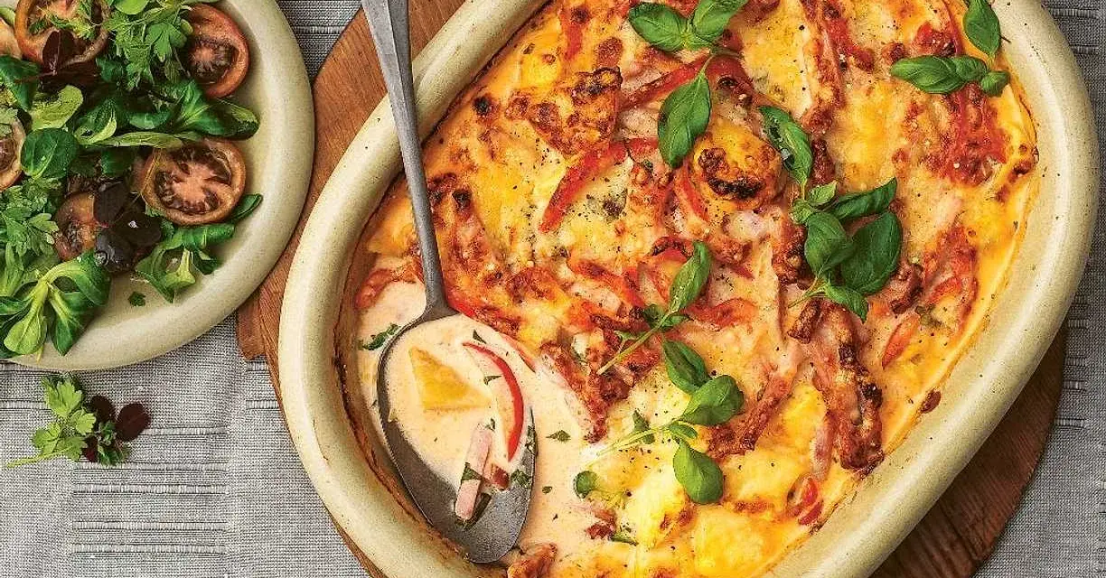 En krämig kasslergratäng med ost och örter, serverad med en fräsch sallad. Ett perfekt kassler recept för middagen.