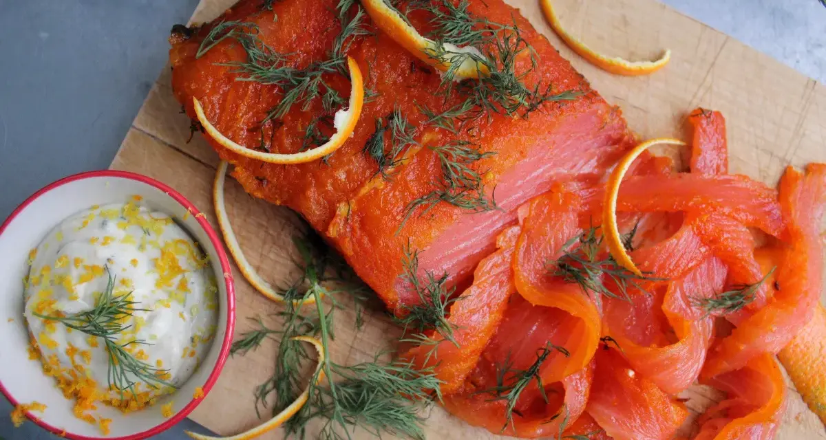 Rökt lax med apelsinzest och dill, serverad med en krämig sås till lax. Perfekt för en festlig måltid.