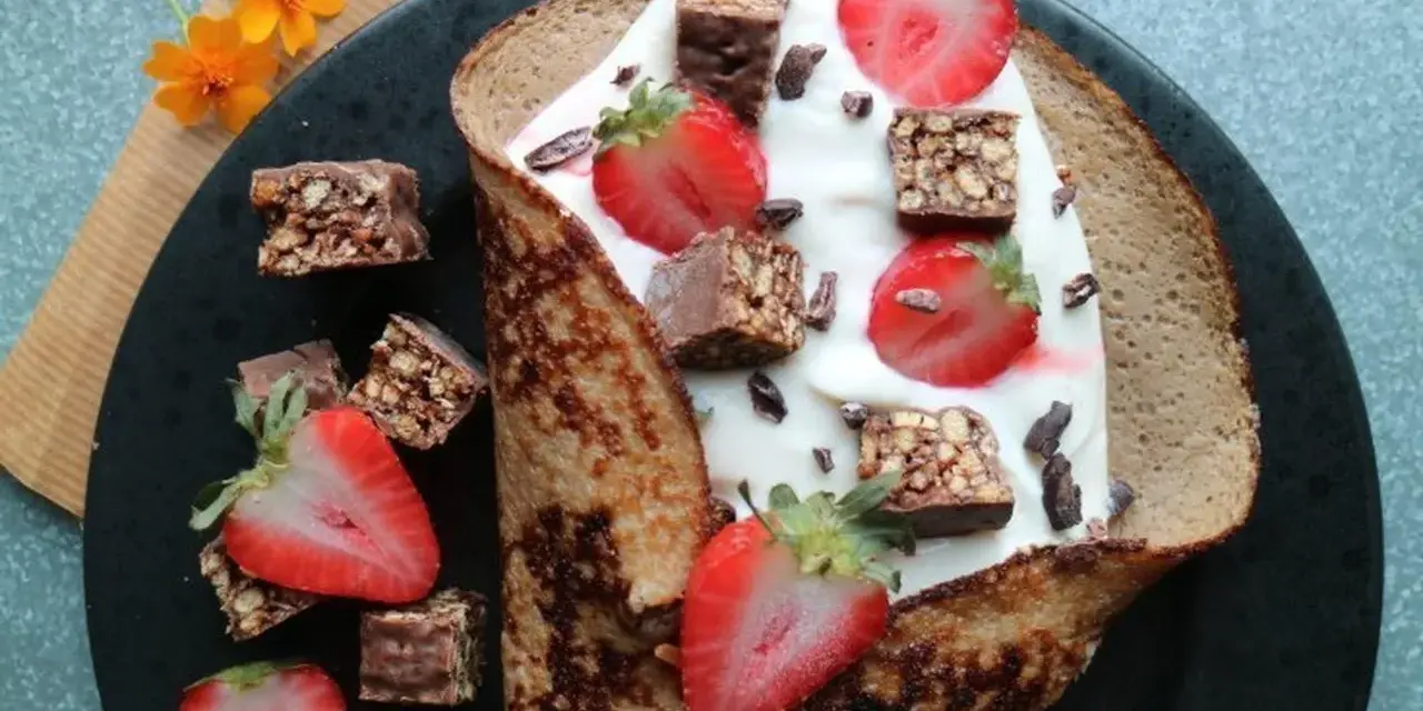 En vikad pannkaka fylld med yoghurt, jordgubbar och chokladbitar. En härlig frukost med nyttiga pannkakor som bas.