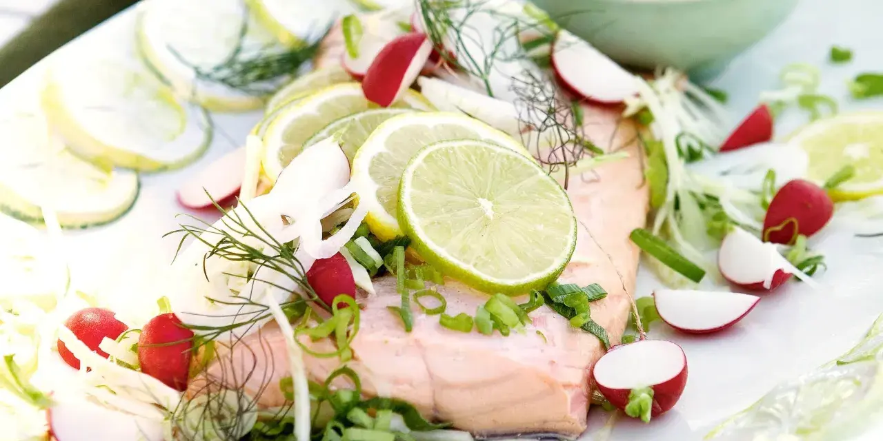 En vacker bit inkokt lax serverad med citronskivor, rädisor, fänkål och dill. En fräsch och somrig rätt.