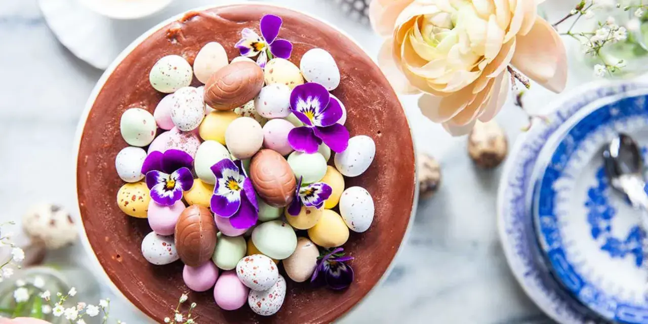 En chokladtårta dekorerad med påskägg i olika färger och violer. En perfekt påsktårta choklad för firandet.