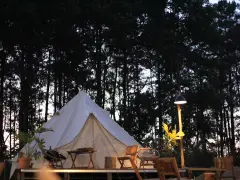 En vit glampingtält står redo för äventyr i en svensk skog. Mysigt och naturnära glamping i Sverige.