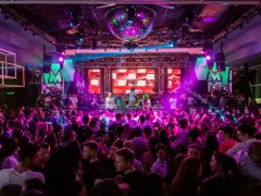 Folk dansar och festar på en 30-årsfest. En discokula hänger i taket och scenen lyses upp av färgglada lampor.