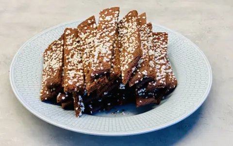 En tallrik med chokladsnittar, toppade med pärlsocker. Perfekt för ett enkelt chokladsnittar recept.