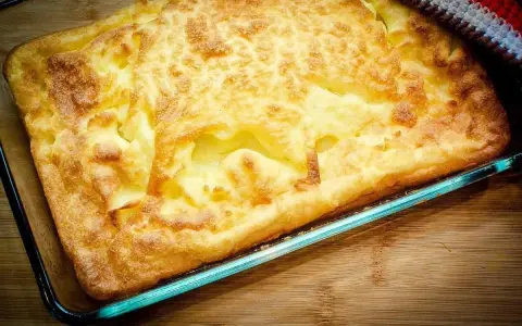 En gyllene, fluffig ugnspannkaka i en glasform, redo att serveras. Ett perfekt ugnspannkaka recept för en mysig fika.