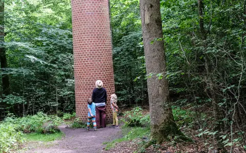 Familj utforskar en tegelkolonn i skogen, en av många Kristianstad aktiviteter.