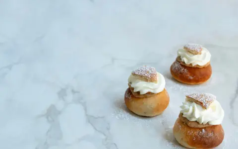 Tre fluffiga semlor med grädde och mandelmassa, pudrade med florsocker. Ett perfekt semlor recept för fika.