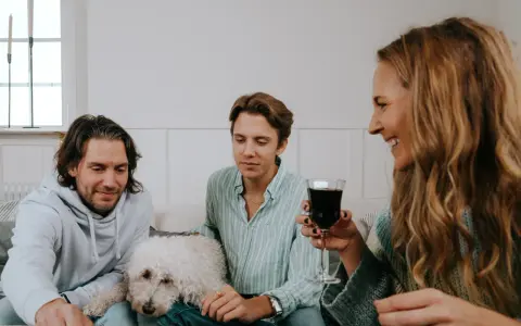 Familj spelar julklappsspelet. Alla får en julklapp, men reglerna kan vara knepiga! En vit hund vilar på soffan.