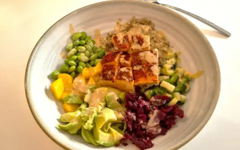 En färgstark bowl med lax, quinoa, edamamebönor, mango, avokado och rödbetor. Perfekt för en snabb middag.