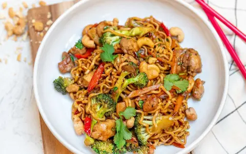 En skål med nudlar, kyckling, broccoli, cashewnötter och paprika. Ett perfekt recept middag för en snabb och god måltid.