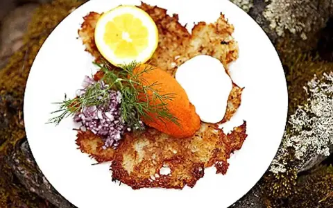 En tallrik med krispiga rårakor, serverade med rom, gräddfil, dill, rödlök och citron. Ett härligt råraka recept!