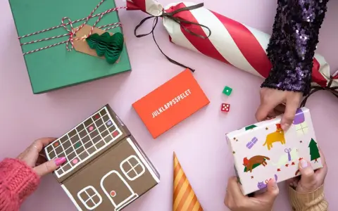 Julklappsleken är igång! Presenter, tärningar och en pepparkakshus-liknande låda ligger redo för att bytas.