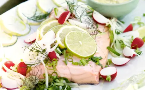 En vacker bit inkokt lax serverad med citronskivor, rädisor, fänkål och dill. En fräsch och somrig rätt.