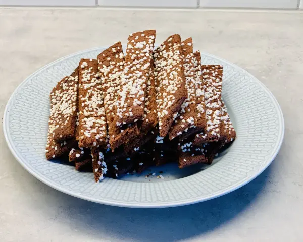 En tallrik med chokladsnittar, toppade med pärlsocker. Perfekt för ett enkelt chokladsnittar recept.