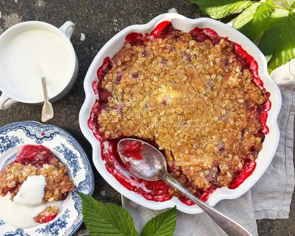 En härlig hallonpaj med krispigt täcke, serverad med vaniljsås. Ett perfekt hallonpaj recept för sommaren.