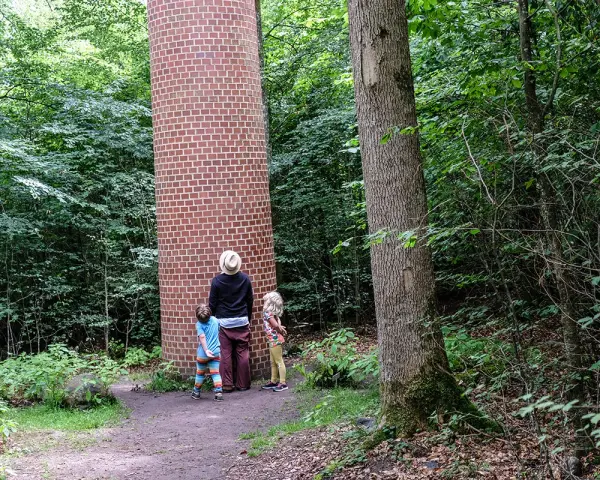 Familj utforskar en tegelkolonn i skogen, en av många Kristianstad aktiviteter.