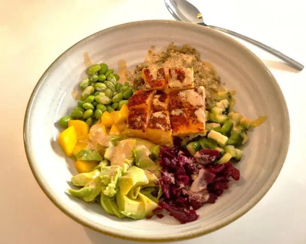 En färgstark bowl med lax, quinoa, edamamebönor, mango, avokado och rödbetor. Perfekt för en snabb middag.