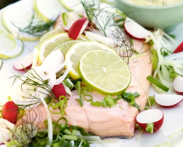 En vacker bit inkokt lax serverad med citronskivor, rädisor, fänkål och dill. En fräsch och somrig rätt.