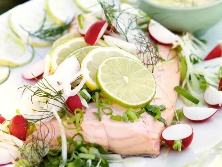 En vacker bit inkokt lax serverad med citronskivor, rädisor, fänkål och dill. En fräsch och somrig rätt.
