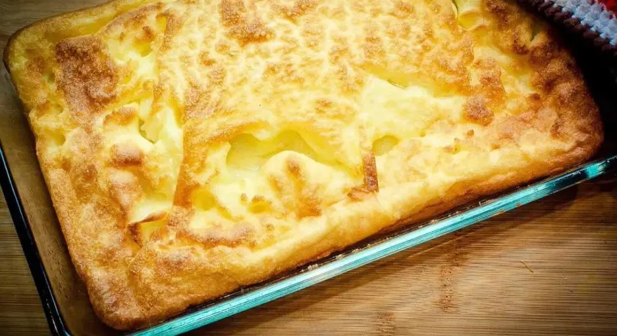 En gyllene, fluffig ugnspannkaka i en glasform, redo att serveras. Ett perfekt ugnspannkaka recept för en mysig fika.