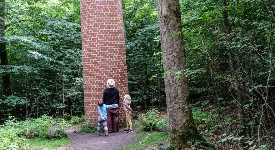 Familj utforskar en tegelkolonn i skogen, en av många Kristianstad aktiviteter.