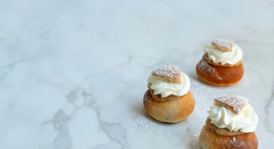Tre fluffiga semlor med grädde och mandelmassa, pudrade med florsocker. Ett perfekt semlor recept för fika.