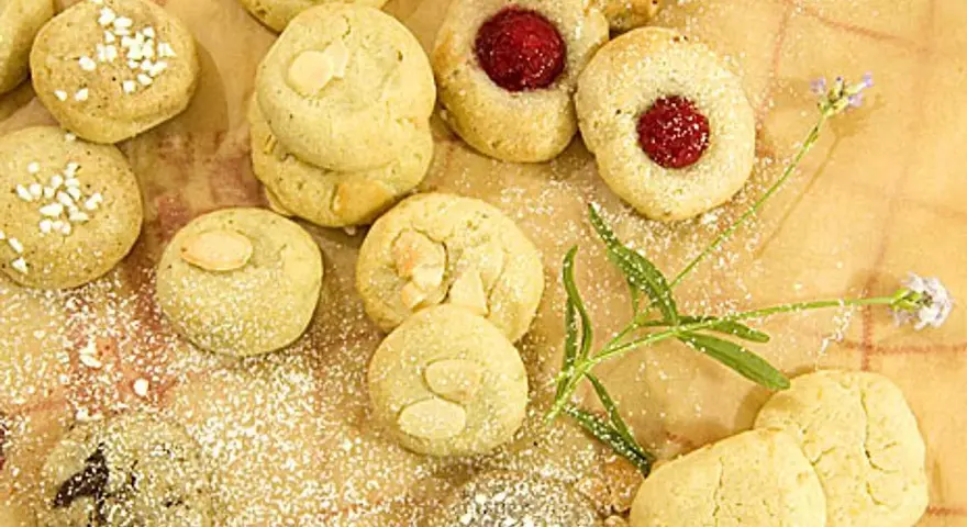 En härlig samling sju sorters kakor recept, pudrade med florsocker. Några med mandel, andra med sylt och några med strössel.