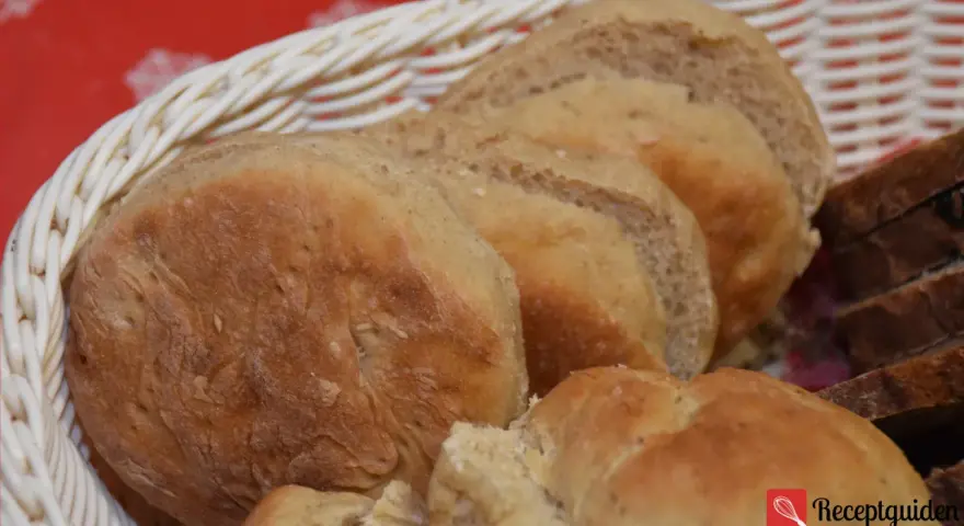 Nybakade grahamsbullar i en korg, perfekta för frukost eller fika. Ett enkelt grahamsbullar recept för hembakat bröd.
