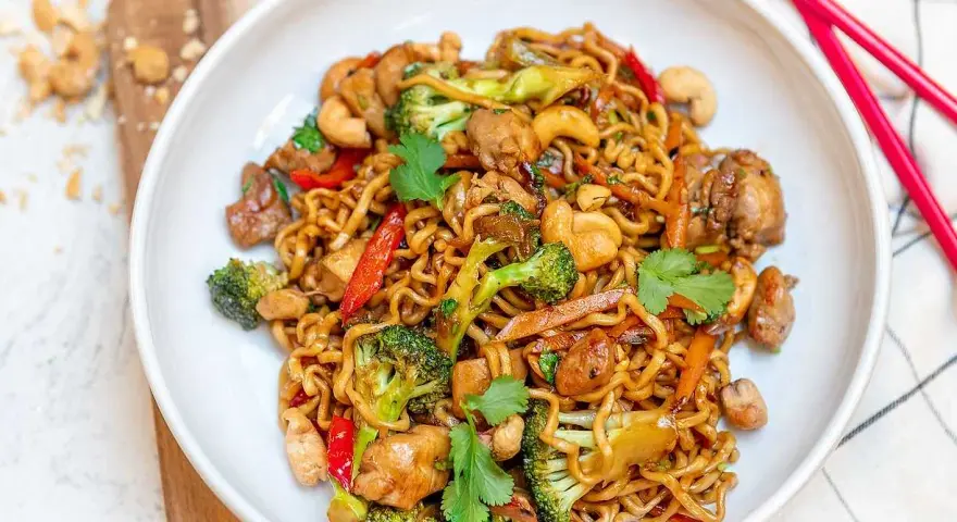 En skål med nudlar, kyckling, broccoli, cashewnötter och paprika. Ett perfekt recept middag för en snabb och god måltid.
